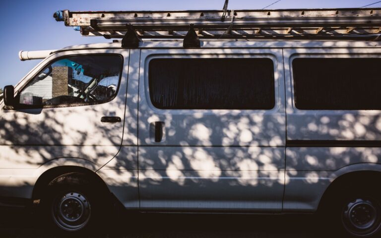 White contractor work van with a ladder rack, the kind of vehicle commercial auto insurance Florida law covers
